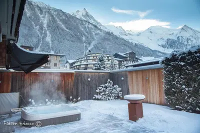 a hot tub in the snow with a mountain at Apartment Au Bon Coin - Luxury Chamonix Hidden Haven, Mont Blanc view, Hot Tub and Garden in Chamonix-Mont-Blanc