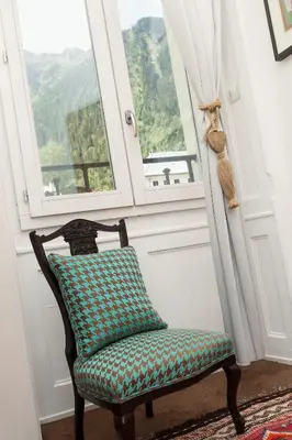 a chair sitting in a room with a window at Apartment Majestic 1 - Central Chamonix Haven Mont Blanc in Chamonix-Mont-Blanc