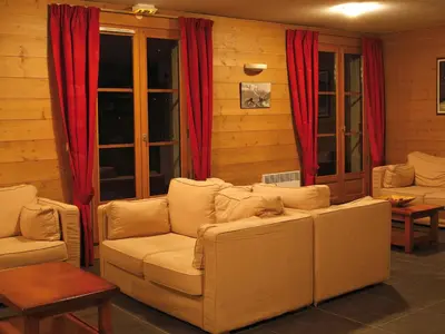 a living room with two couches and red curtains at Lagrange Vacances Les Arolles in Saint-Gervais-les-Bains