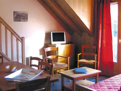 a living room with chairs and a table and a tv at Lagrange Vacances Les Arolles in Saint-Gervais-les-Bains
