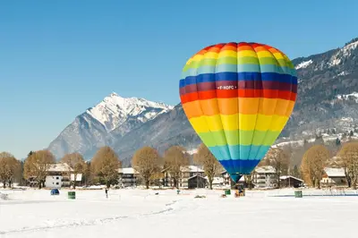 a colorful hot air balloon flying in the snow at Lagrange Vacances Les Fermes de Samoëns in Samoëns