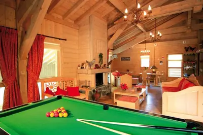 a living room with a pool table in a cabin at Lagrange Vacances Les Fermes de Samoëns in Samoëns