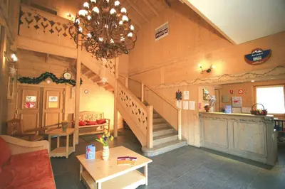 a living room with a staircase and a chandelier at Lagrange Vacances Les Fermes de Samoëns in Samoëns