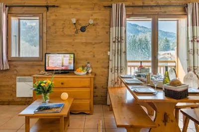 a room with wooden walls and tables and a computer at Lagrange Vacances Les Fermes de Samoëns in Samoëns