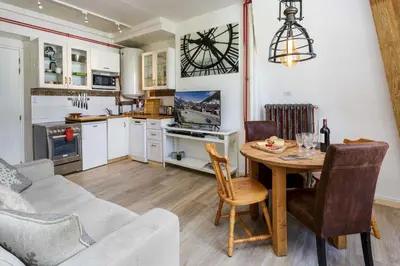 a kitchen and living room with a table and a couch at Mont Blanc 212 Apartment - Chamonix All Year in Chamonix-Mont-Blanc