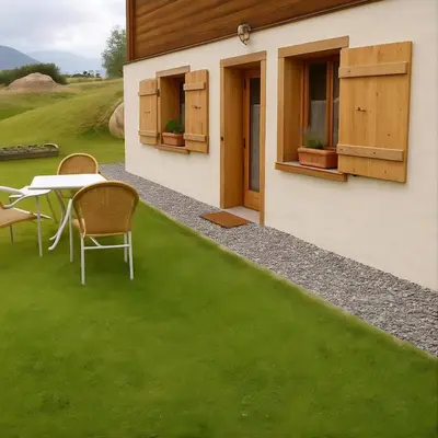 a backyard with green grass and a table and chairs at megeve appartement des Crêtets in Megève