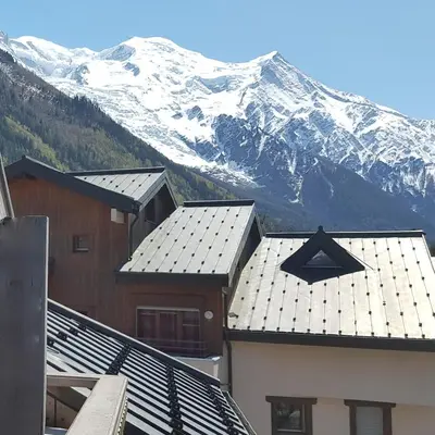 a view of snow covered mountains from the roofs of buildings at Appartement Les Arolles in Chamonix-Mont-Blanc
