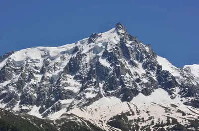 a snow covered mountain with a blue sky at Appartement Les Arolles in Chamonix-Mont-Blanc