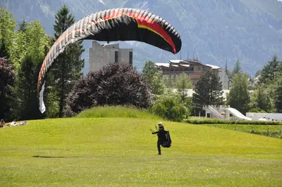 a person is flying a kite in a field at Appartement Les Arolles in Chamonix-Mont-Blanc