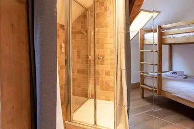 a glass shower in a room with a bunk bed at La Belle Epoque - Chamonix All Year in Chamonix-Mont-Blanc