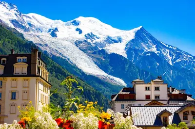 a city with a snow covered mountain in the background at La Belle Epoque - Chamonix All Year in Chamonix-Mont-Blanc