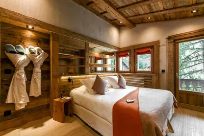 a bedroom with a bed and a large window at Au Coin Du Feu in Megève