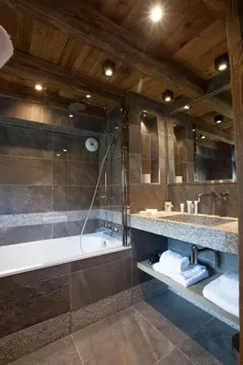 a bathroom with a tub and a sink and a shower at Au Coin Du Feu in Megève