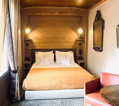 a bedroom with a large bed with a wooden headboard at Coeur des Neiges in Saint-Gervais-les-Bains