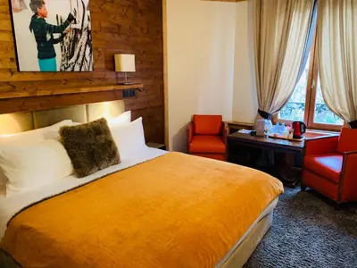 a hotel room with a bed and a desk and a chair at Coeur des Neiges in Saint-Gervais-les-Bains