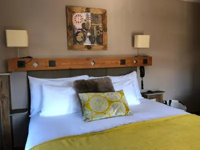 a bedroom with a white bed with a wooden headboard at Coeur des Neiges in Saint-Gervais-les-Bains
