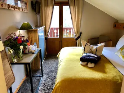 a hotel room with a bed with a teddy bear on it at Coeur des Neiges in Saint-Gervais-les-Bains