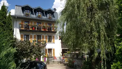 a white building with flower boxes on its windows at Hotel Du Clocher in Chamonix-Mont-Blanc