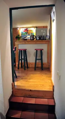 a kitchen with a counter and stools in a room at Hotel Du Clocher in Chamonix-Mont-Blanc