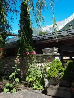 a garden with flowers in front of a building at Hotel Du Clocher in Chamonix-Mont-Blanc
