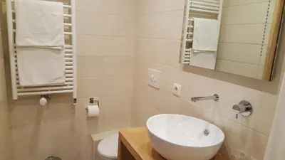 a white bathroom with a sink and a toilet at Hotel Du Clocher in Chamonix-Mont-Blanc