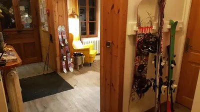 a room with skis and snowboards leaning against a wall at Hotel Du Clocher in Chamonix-Mont-Blanc