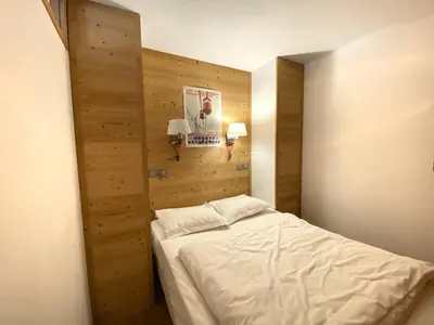a bedroom with a bed and a wooden wall at Hôtel Rent in Megève
