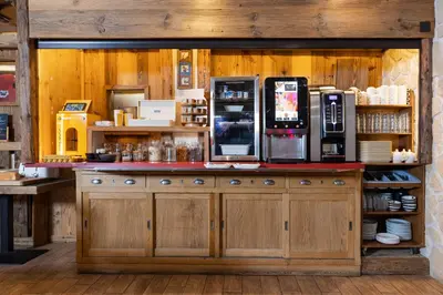 a coffee shop with a counter with a coffee machine at Le Saint Antoine in Les Houches