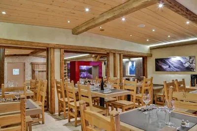 a dining room with wooden tables and chairs at Le Saint Antoine in Les Houches