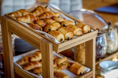 a display case with several trays of pastries at Hôtel Les Roches Fleuries in Cordon