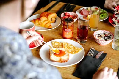 a table with plates of breakfast food on it at Hôtel Les Roches Fleuries in Cordon