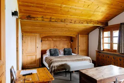 a bedroom with a bed and a wooden ceiling at Hôtel Les Roches Fleuries in Cordon