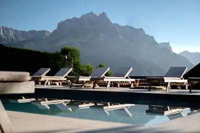 a row of lounge chairs sitting next to a swimming pool at Hôtel Les Roches Fleuries in Cordon