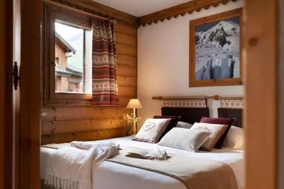 a kitchen with wooden cabinets and a sink at Résidence Pierre & Vacances Premium La Ginabelle in Chamonix-Mont-Blanc