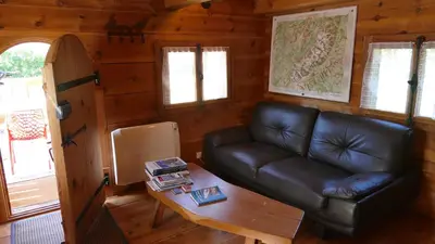 a living room with a leather couch and a table at Chamonix petit chalet Cocooning in Servoz
