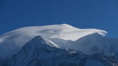 a white cloud over a snow covered mountain at Chamonix petit chalet Cocooning in Servoz