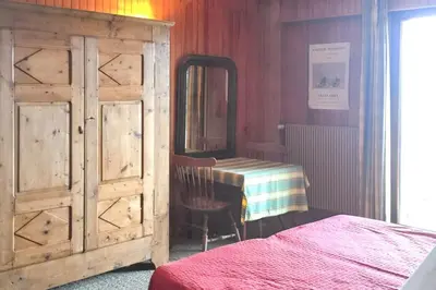 a bedroom with a dresser and a mirror and a bed at Chalet spacieux à Cordon 180 m² avec vue montagne in Cordon