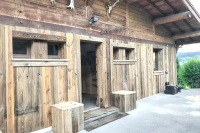 a barn with wooden walls and doors and two benches at Chalet spacieux à Cordon 180 m² avec vue montagne in Cordon