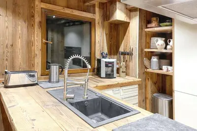 a kitchen with a sink in a wooden kitchen at Chalet spacieux à Cordon 180 m² avec vue montagne in Cordon