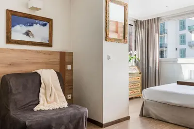a hotel room with a chair and a bed at Hôtel Vallée Blanche in Chamonix-Mont-Blanc