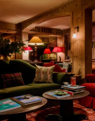 a living room with a green couch and a table at Hôtel Saint-Georges Relais & Châteaux in Megève