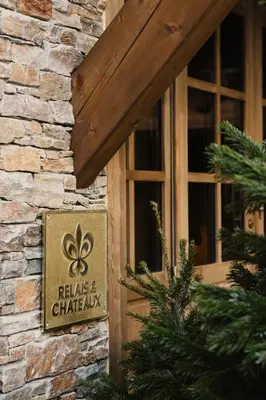 a sign on the side of a building with a window at Hôtel Saint-Georges Relais & Châteaux in Megève
