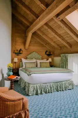 a bedroom with a large bed with a wooden ceiling at Hôtel Saint-Georges Relais & Châteaux in Megève