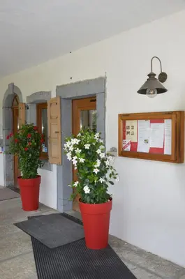 two plants in red pots on the side of a building at Le Relais Du Mont Blanc in Magland