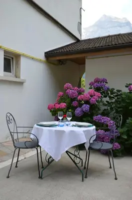 a table and two chairs with wine glasses on it at Le Relais Du Mont Blanc in Magland