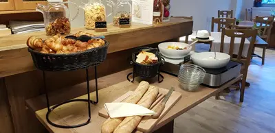 a table with a bunch of bread and other foods at Le Relais Du Mont Blanc in Magland