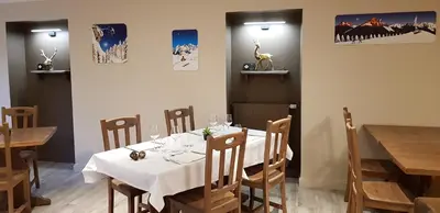 a dining room with a white table and wooden chairs at Le Relais Du Mont Blanc in Magland