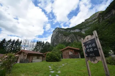a sign in a field with houses and a mountain at Le Relais Du Mont Blanc in Magland