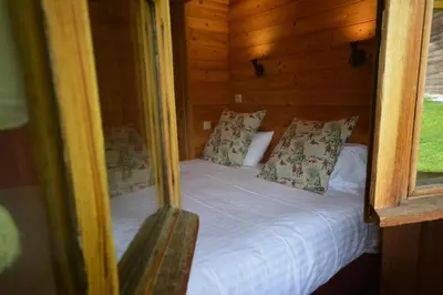 a bedroom with a bed in a wooden cabin at Le Relais Du Mont Blanc in Magland