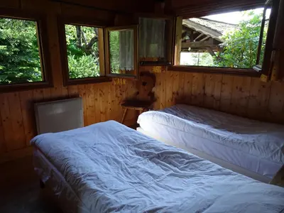 two beds in a room with two windows at Chalet des Glaciers in Chamonix-Mont-Blanc